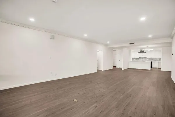 a view of empty room with wooden floor