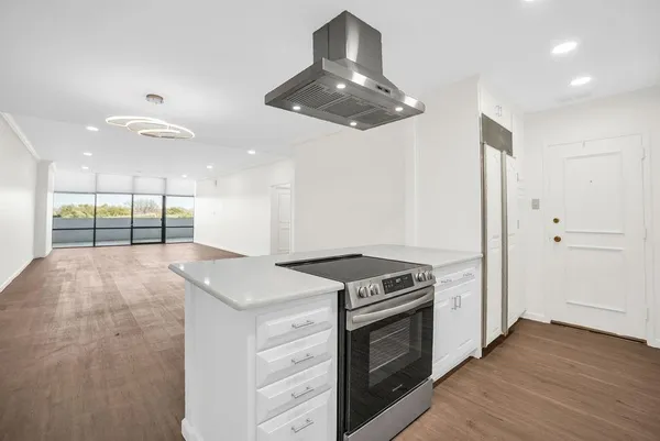 a kitchen with a stove and a wooden floor