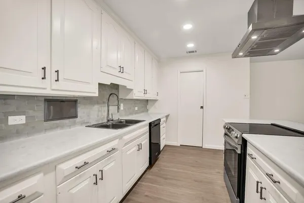 a kitchen with granite countertop a sink stainless steel appliances and cabinets
