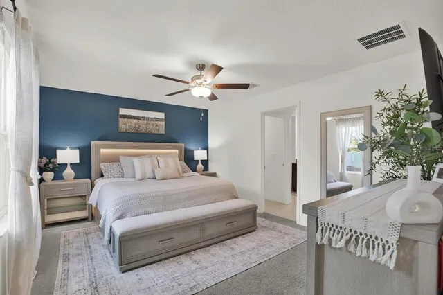 a bedroom with a large bed and a chandelier