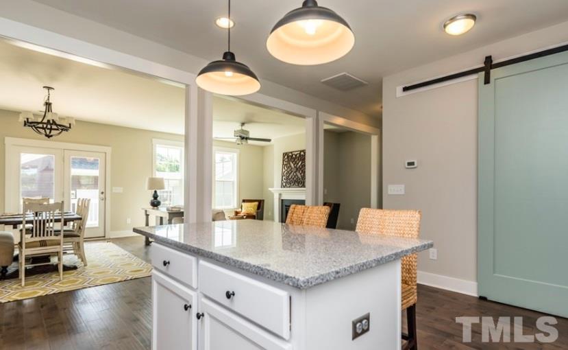 288 Daniel Ridge Rd., Unit 1209 Wendell, NC 27591 - Photo 3 of 9 a dining hall with stainless steel appliances granite countertop a dining table chairs and chandelier