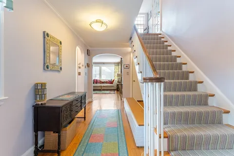 a view of a hallway with furniture and wooden floor