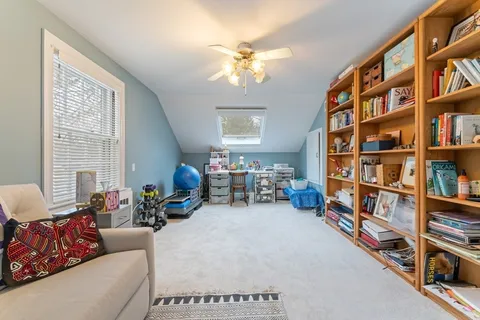 a living room with furniture and a book shelf