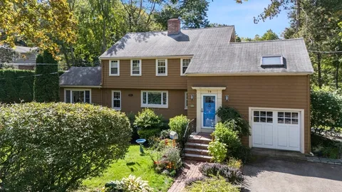 front view of house with a yard and potted plants