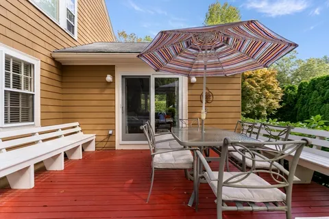 a view of a patio with table and chairs with wooden floor and fence