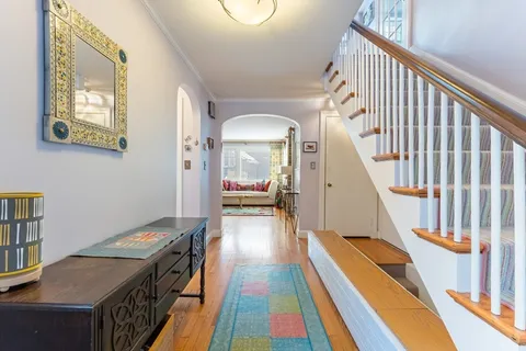 a view of a hallway with wooden floor and staircase