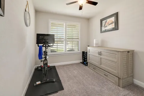 a room with gym equipment and a flat screen tv