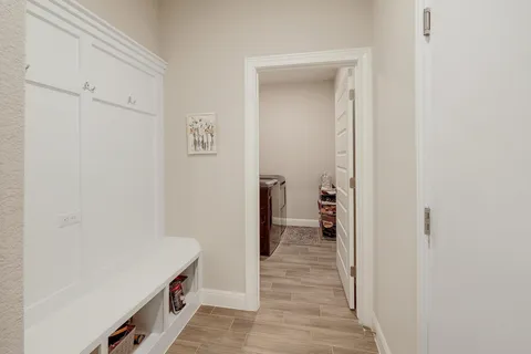 a view of a hallway with wooden floor and closet