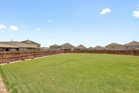 a view of a patio with table and chairs next to a yard