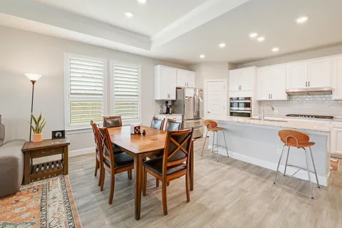 a dining room with a table chairs and a kitchen view