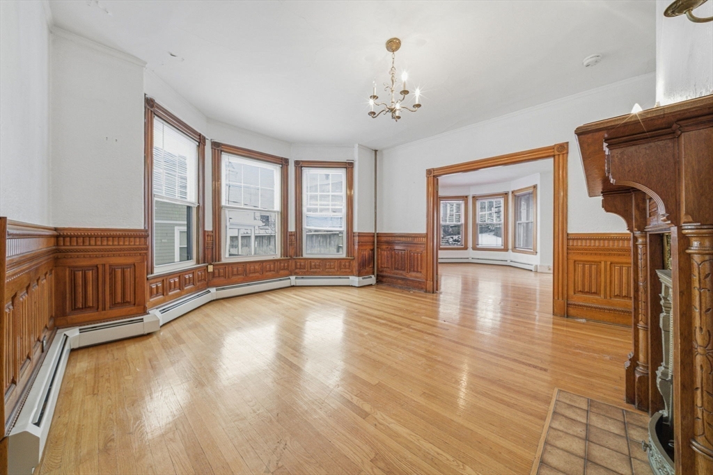 87 Burt Street Boston, MA 02124 - Photo 13 of 40 a view of an empty room with wooden floor and a window