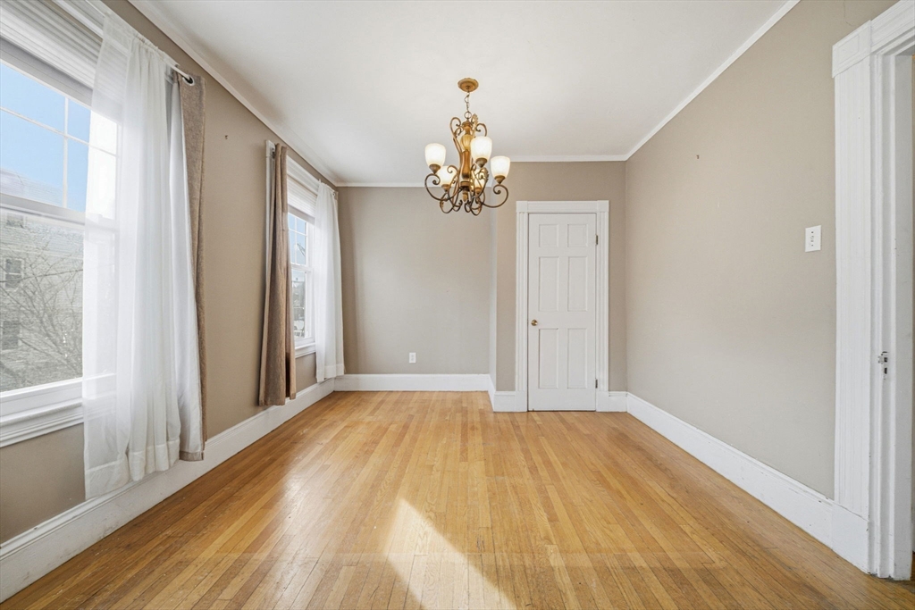 87 Burt Street Boston, MA 02124 - Photo 21 of 40 a view of a chandelier in hallway with wooden floor and chandelier