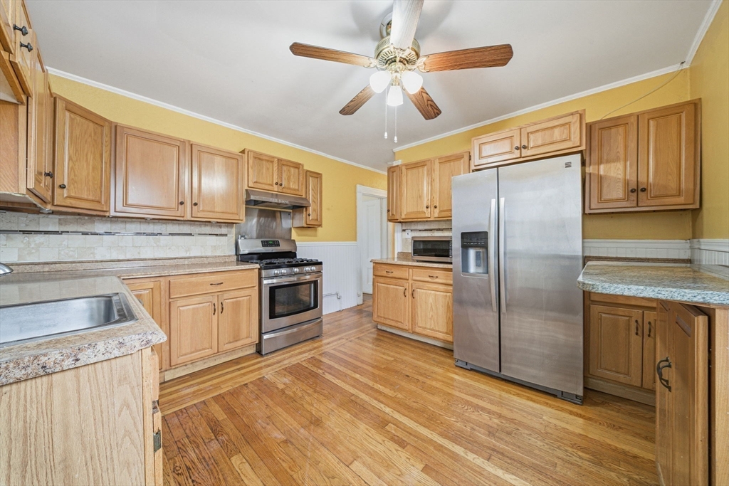 87 Burt Street Boston, MA 02124 - Photo 24 of 40 a kitchen with stainless steel appliances granite countertop a refrigerator a stove a sink and dishwasher with wooden floor