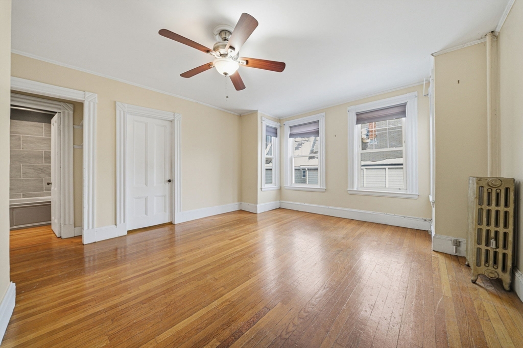 87 Burt Street Boston, MA 02124 - Photo 25 of 40 a view of an empty room with wooden floor and a window