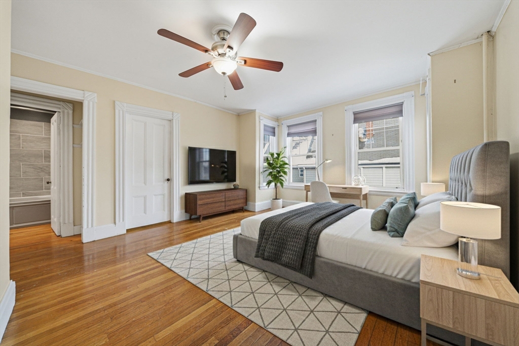 87 Burt Street Boston, MA 02124 - Photo 26 of 40 a bedroom with a large bed a flat tv screen and a dresser