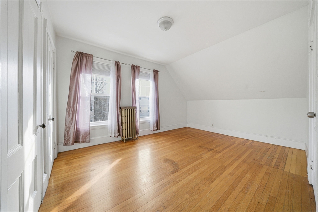 87 Burt Street Boston, MA 02124 - Photo 29 of 40 a view of empty room with wooden floor and fan