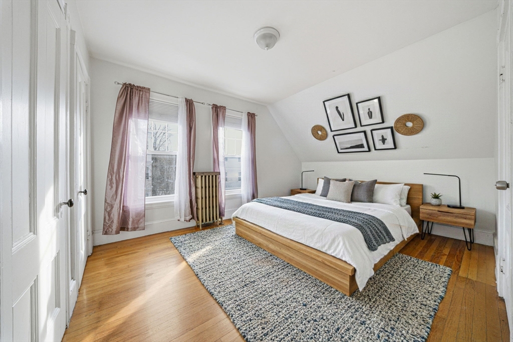 87 Burt Street Boston, MA 02124 - Photo 30 of 40 a spacious bedroom with a bed and glass door