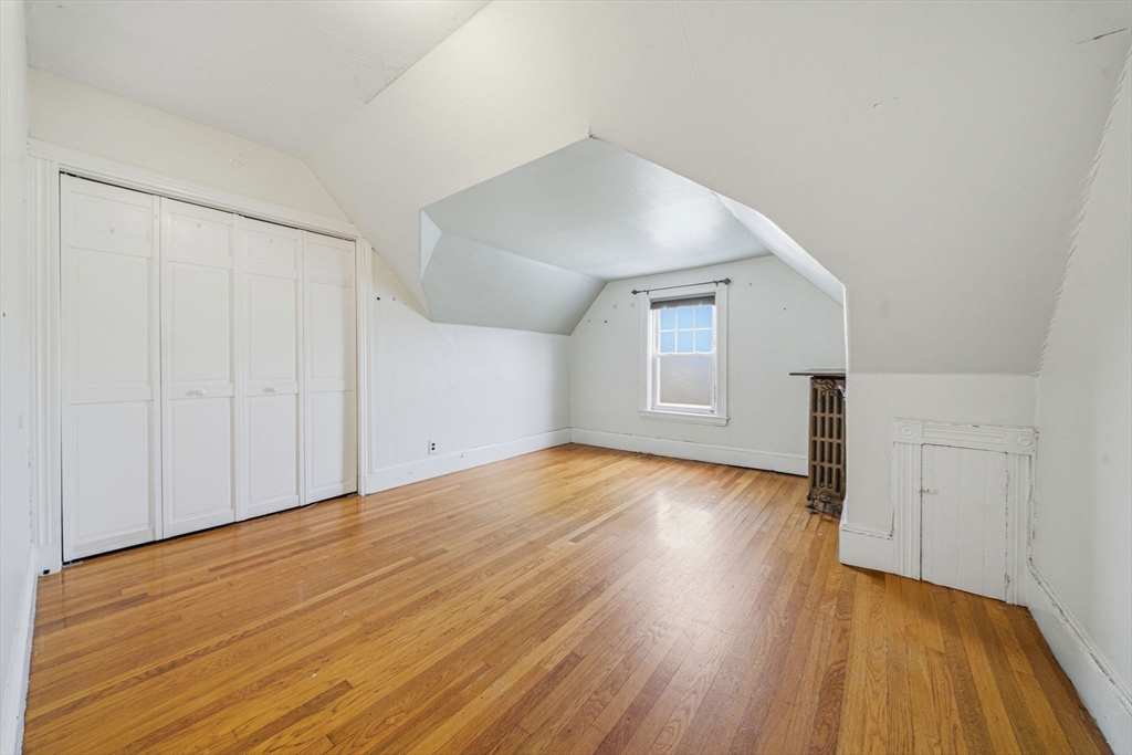 87 Burt Street Boston, MA 02124 - Photo 31 of 40 a view of empty room with wooden floor and fan
