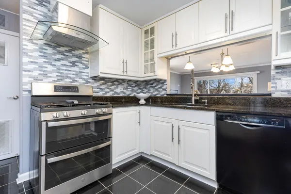 a kitchen with white cabinets and appliances