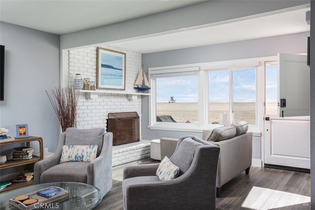 200 East Oceanfront Newport Beach, CA 92661 - Photo 8 of 36 a living room with furniture a large window and a fireplace