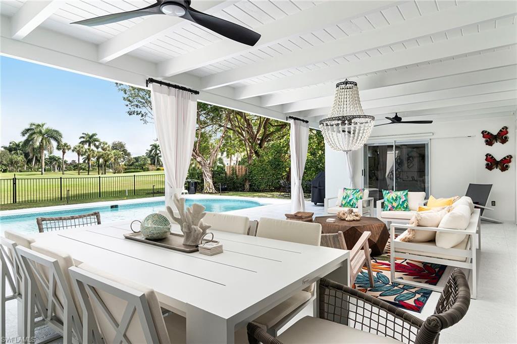 2728 Crayton Road Naples, FL 34103 - Photo 11 of 14 a living room with furniture a large window and a table