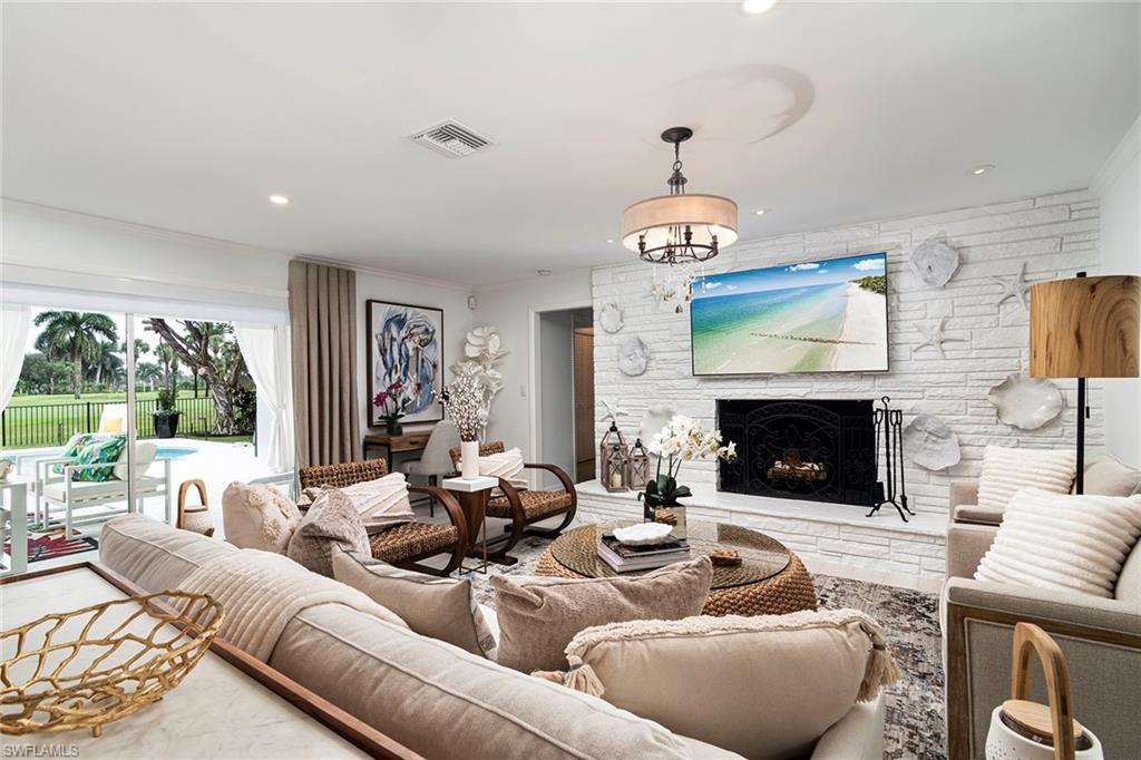2728 Crayton Road Naples, FL 34103 - Photo 2 of 14 a living room with furniture and a fireplace