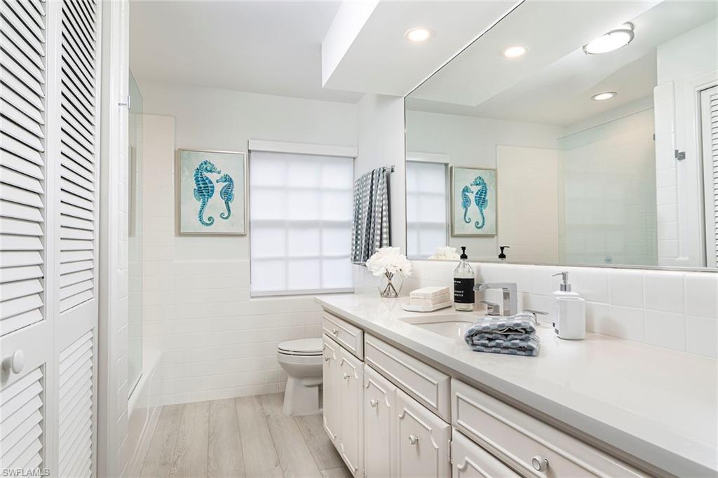 2728 Crayton Road Naples, FL 34103 - Photo 7 of 14 a bathroom with a sink a toilet and a window