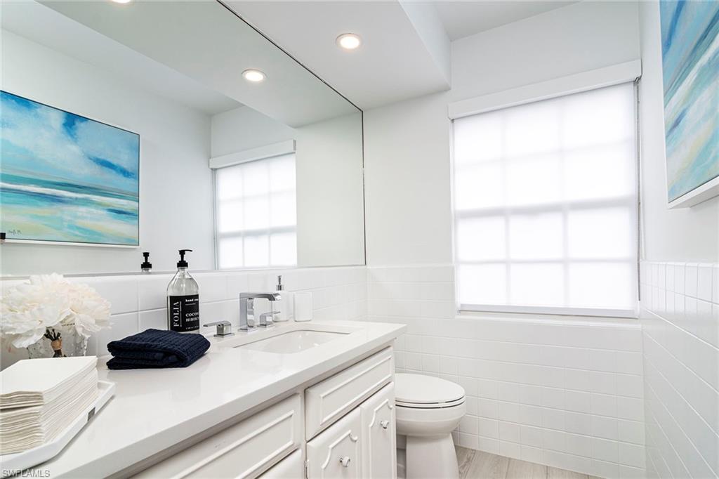 2728 Crayton Road Naples, FL 34103 - Photo 9 of 14 a kitchen with a sink a window and a toilet