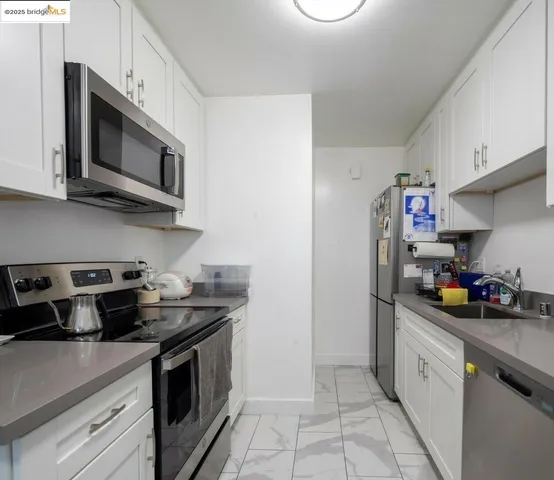 a kitchen with stainless steel appliances granite countertop a sink a stove and cabinets