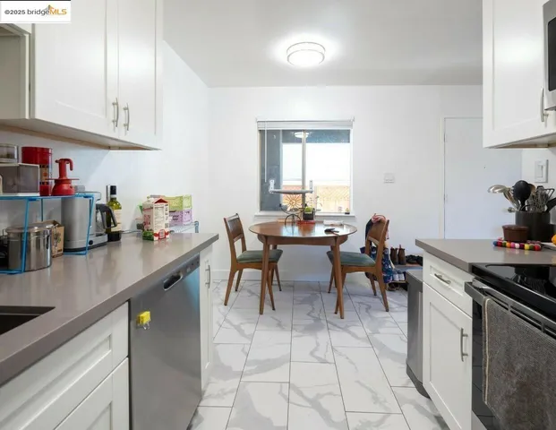 a kitchen with granite countertop a sink dining table and chairs