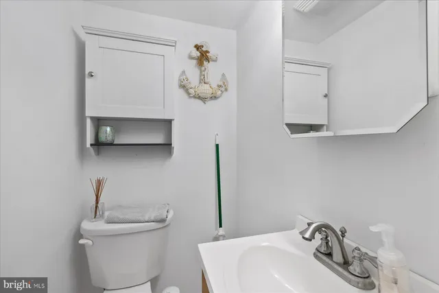 a bathroom with a sink mirror and toilet