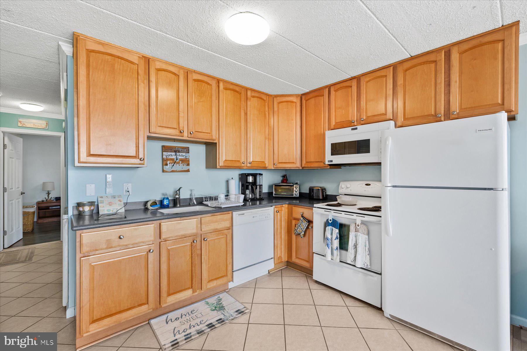14 38th Street, Unit 301 Ocean City, MD 21842 - Photo 2 of 20 a kitchen with stainless steel appliances granite countertop a refrigerator sink stove and white cabinets