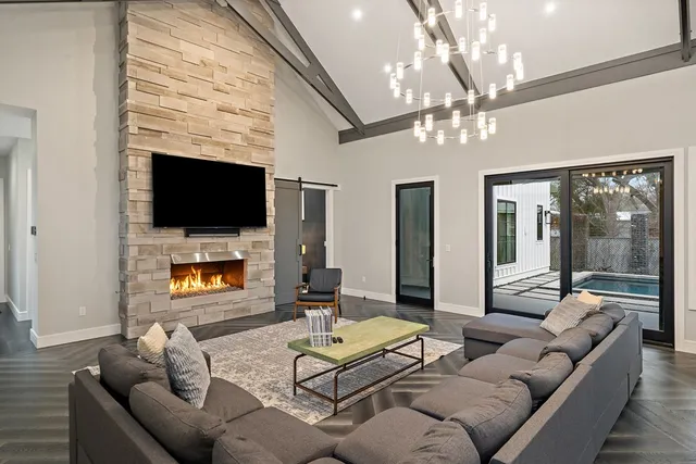 a living room with furniture a flat screen tv and a chandelier