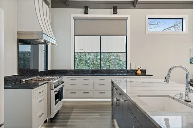 a kitchen with a sink stove top oven and cabinets