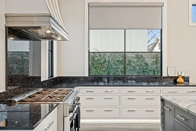 a kitchen with a stove a sink and a window