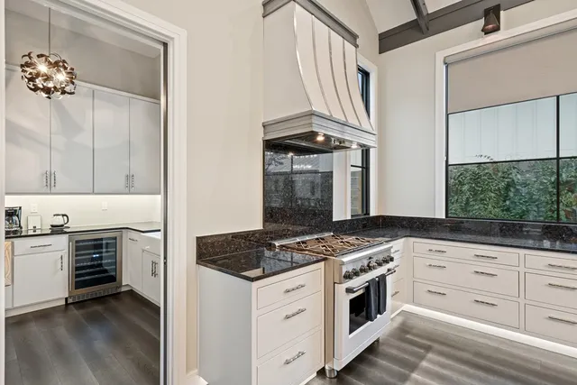 a kitchen with white cabinets and appliances