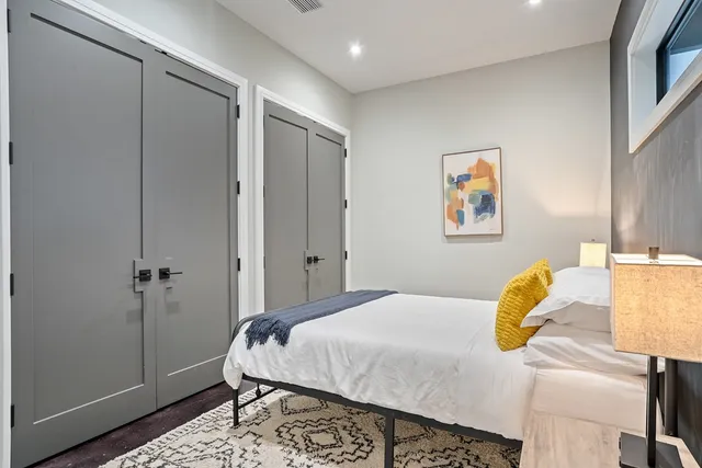 a bedroom with a bed and painting on the wall