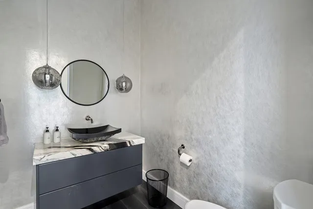 a bathroom with a granite countertop toilet and a sink