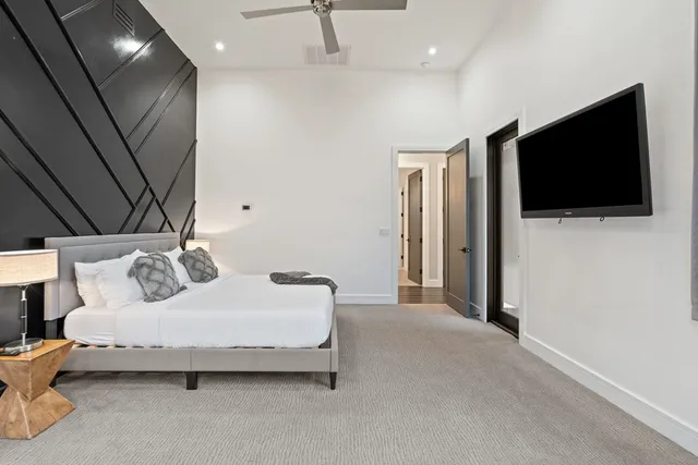 a spacious bedroom with a bed and a flat screen tv