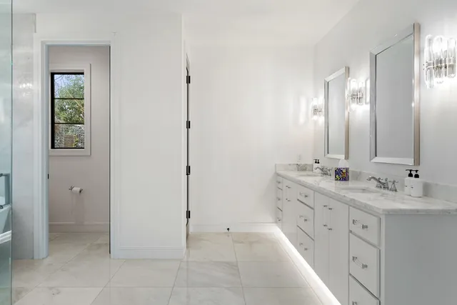 a bathroom with a double vanity sink a mirror and a bathtub
