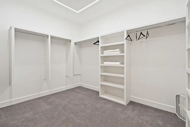 a view of walk in closet with empty racks