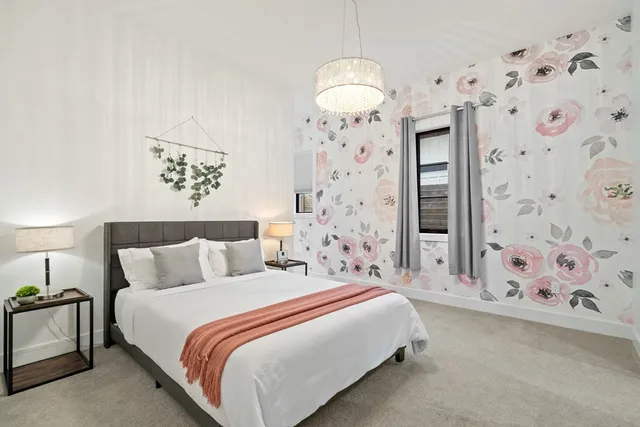 a bedroom with bed and a chandelier