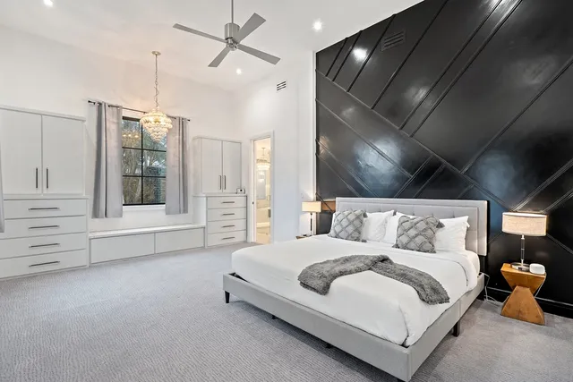 a spacious bedroom with a bed and ceiling fan