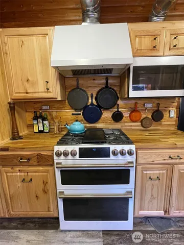 a kitchen with a stove and a wooden floor