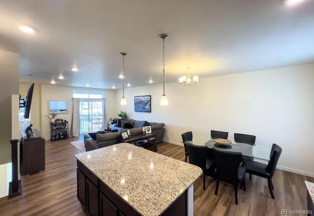 a living room with dining table a couch and wooden floor