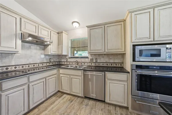 a kitchen with stainless steel appliances granite countertop a stove sink and cabinets