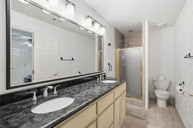 a bathroom with a granite countertop sink toilet and shower