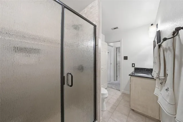 a bathroom with a granite countertop shower sink and toilet