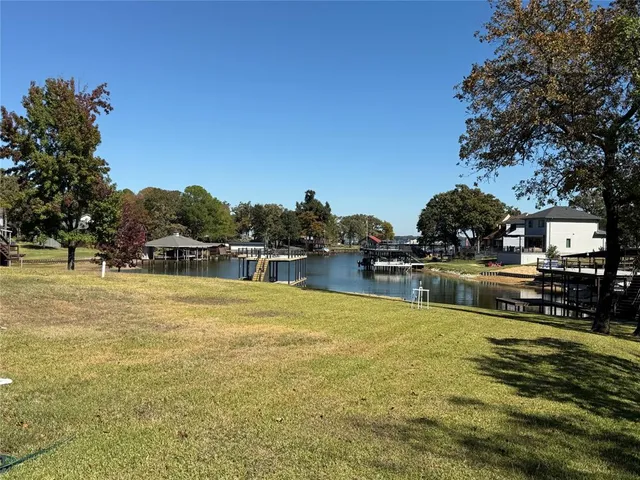 a swimming pool that has lawn chairs and a dining table under an umbrella