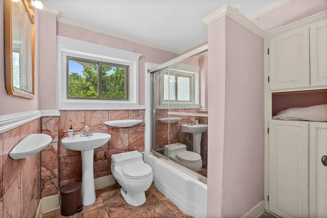 a bathroom with a toilet sink and mirror